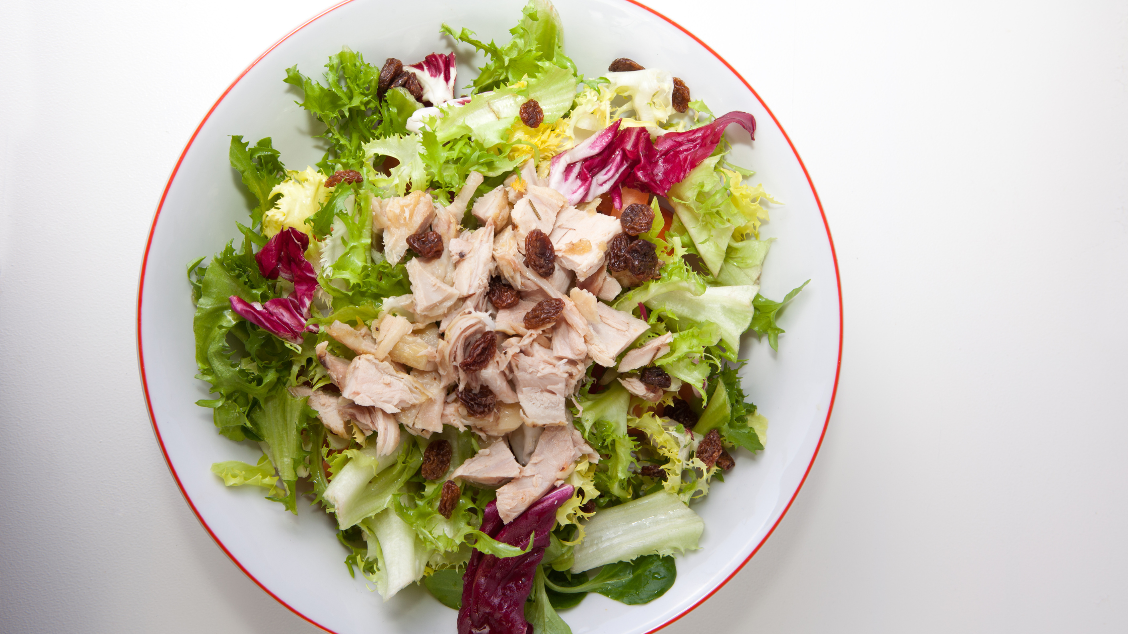 Ensalada iceberg con pollo asado y toque dulce de pasas
